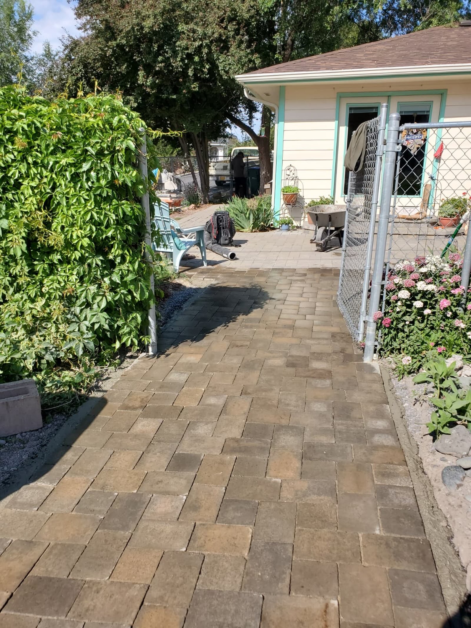 Finished paver walkway leading to a backyard patio